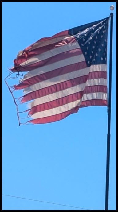 Worn and tattered American flag in need of retirement and replacement